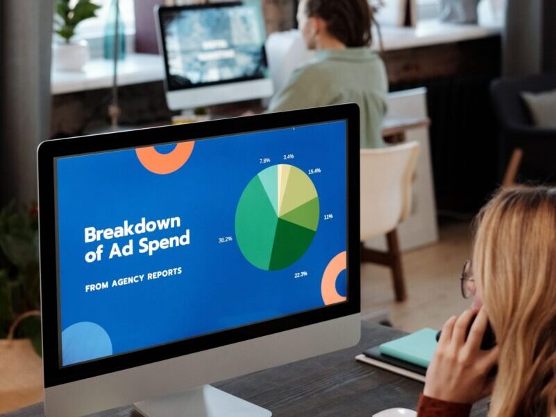 Bright office setting with computers displaying data, illustrating productivity in a workspace.